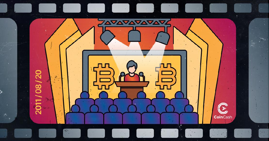 Egy színpadon álló előadó ember, a színpad hátterében BTC logóval